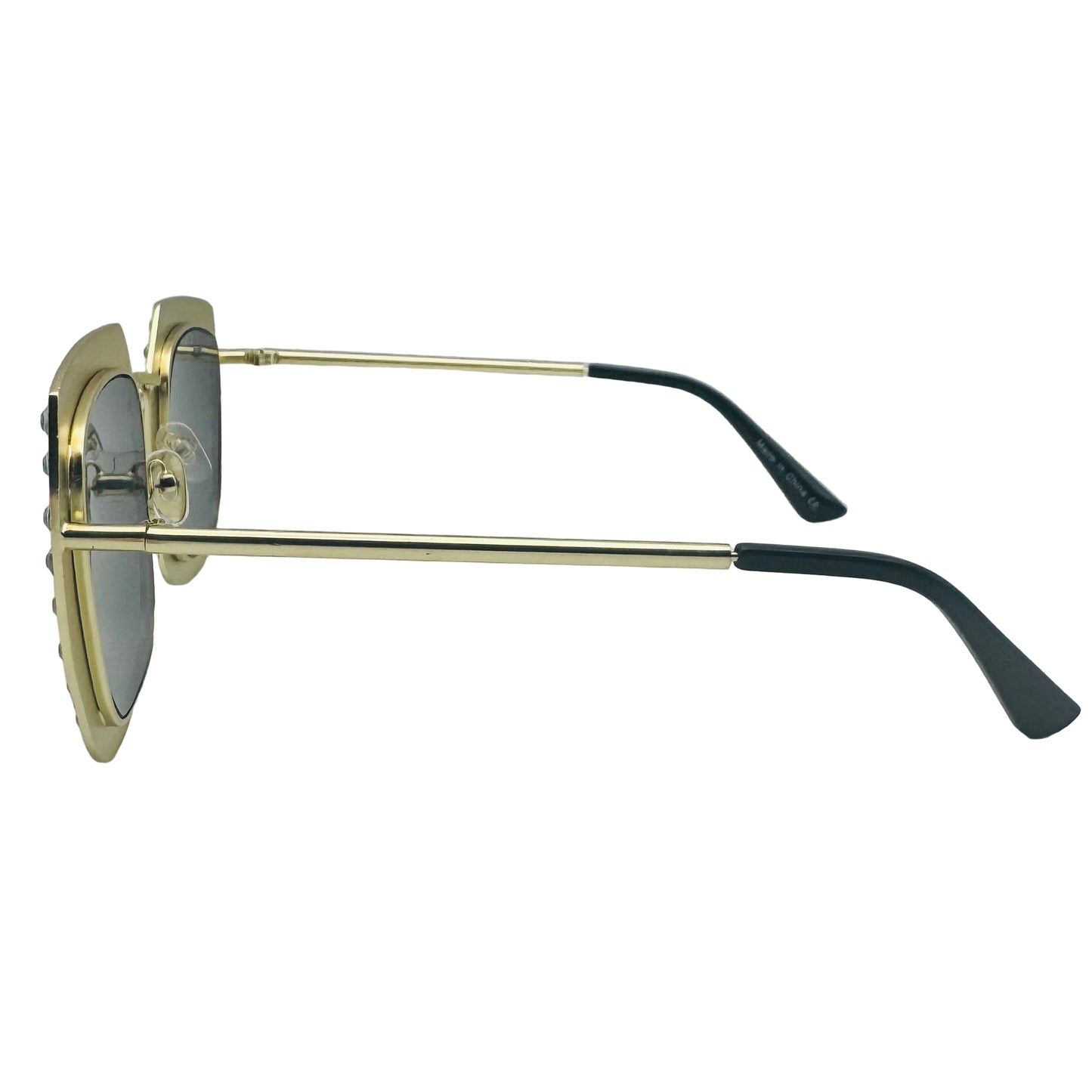 Sunglasses with gold frame and black arms on a light gray background