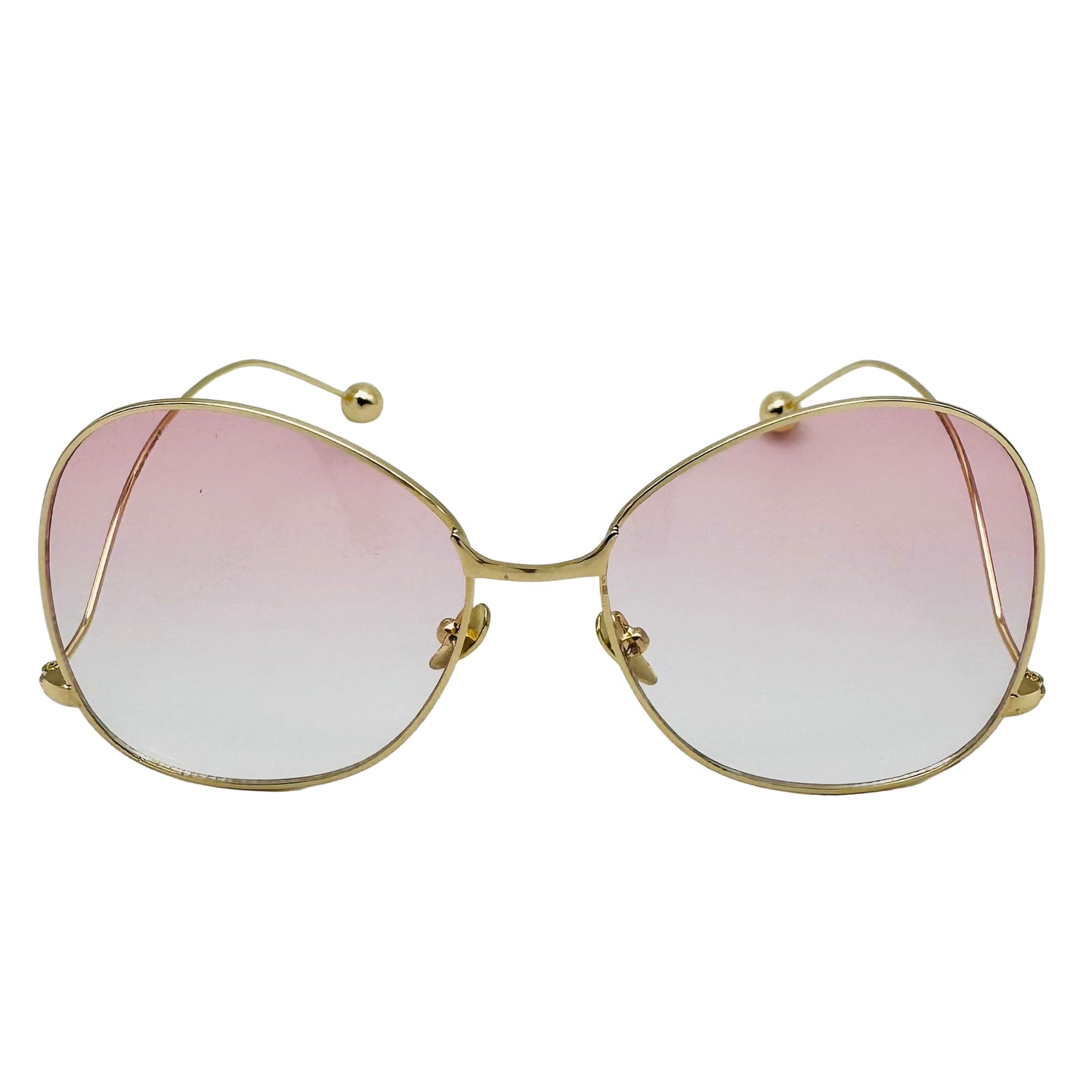 Gold-framed sunglasses with pink gradient lenses on a white background