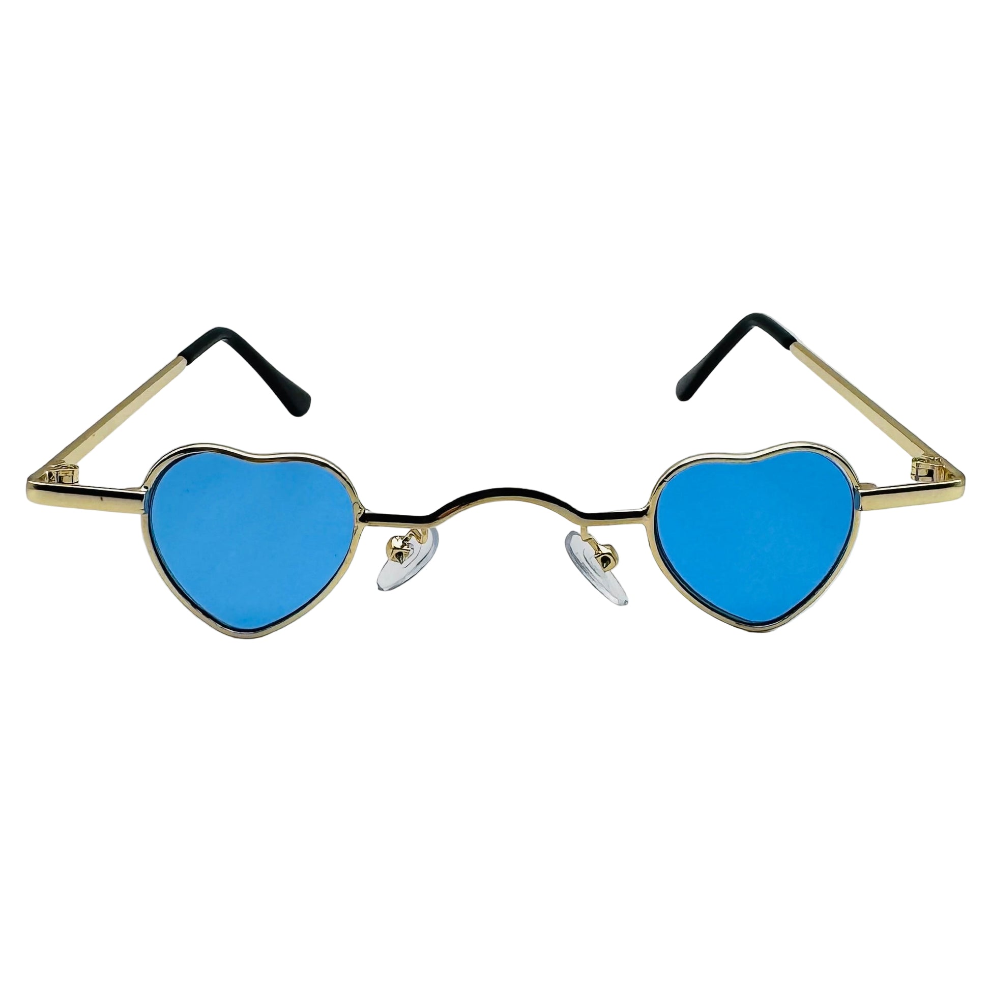 Heart-shaped sunglasses with blue lenses and gold frames on a light gray background