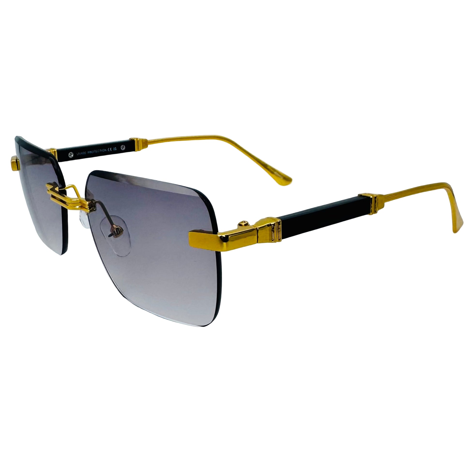 Sunglasses with gold and black frame on a light gray background