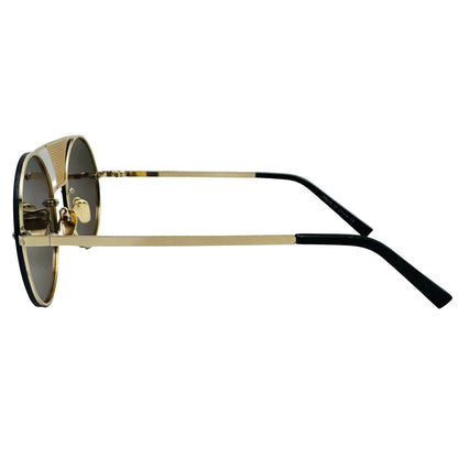 Sunglasses with gold frame and black arms on a light gray background