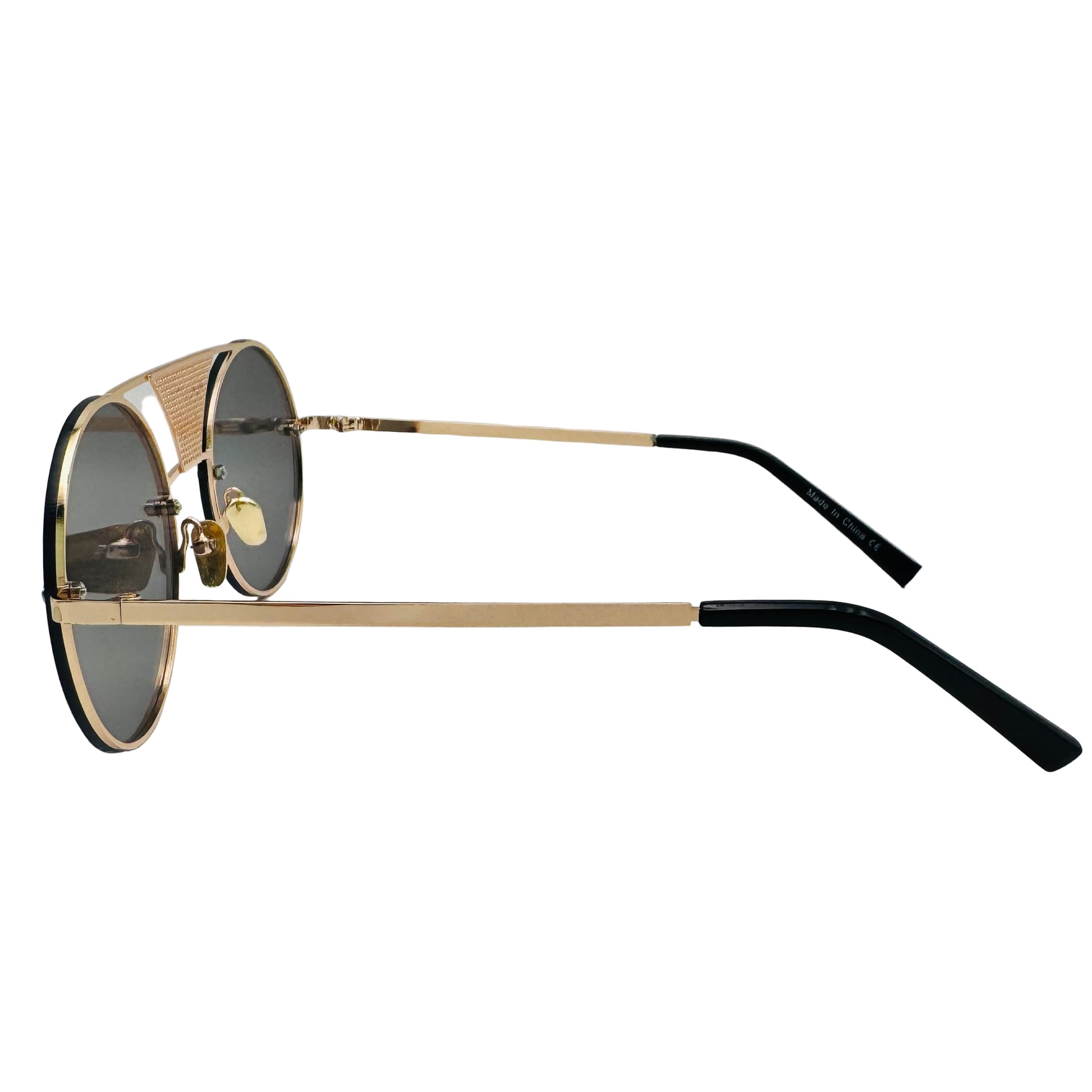 Sunglasses with gold frame and black arms on a light gray background