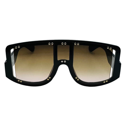 Black sunglasses with gold accents on a light gray background