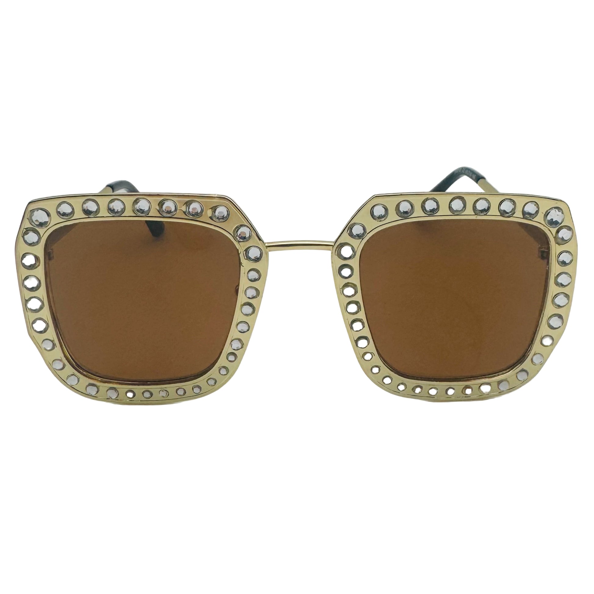 Sunglasses with gold frame and brown lenses on a white background
