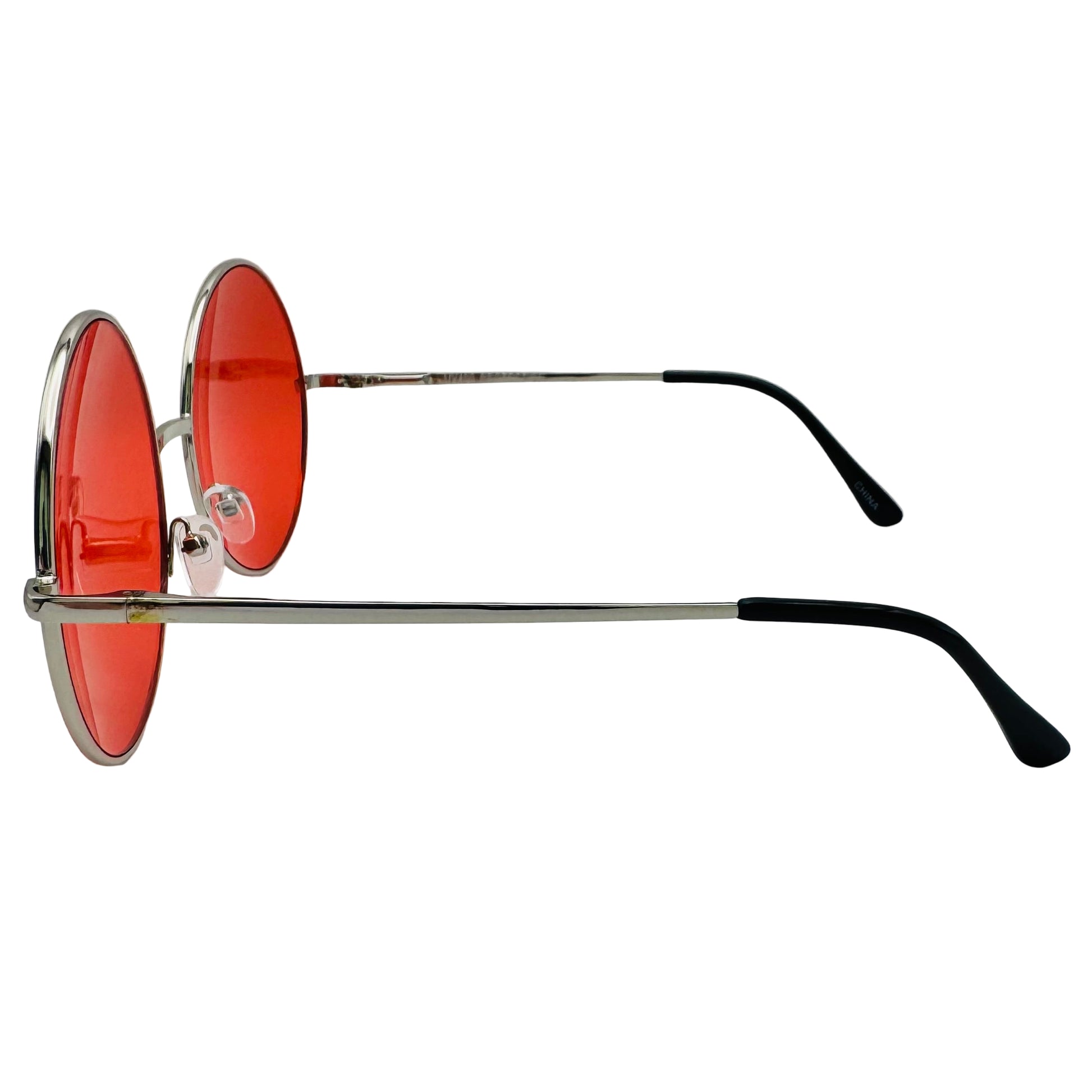 Sunglasses with red lenses and black arms on a light gray background