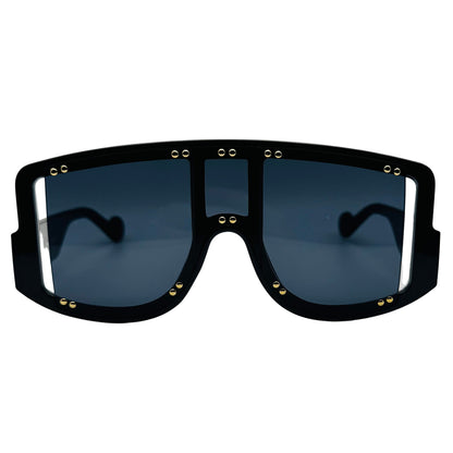 Black sunglasses with gold accents on a light gray background