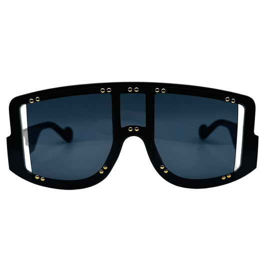 Black sunglasses with gold accents on a light gray background