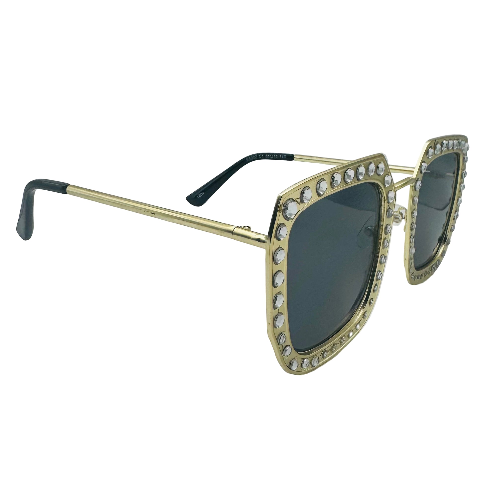 Gold-framed sunglasses with gemstones on a gray background