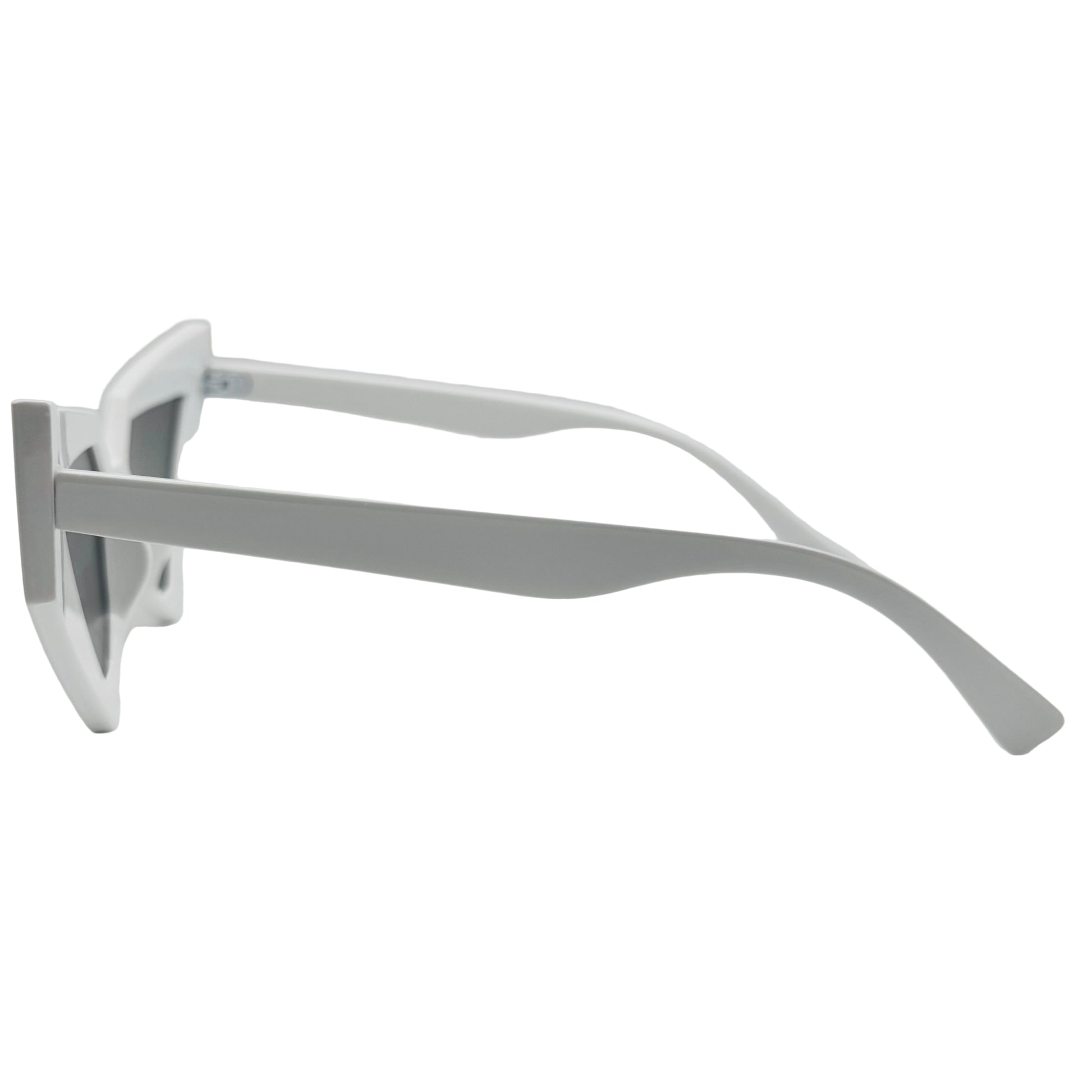 Silver sunglasses on a white surface with a light gray background