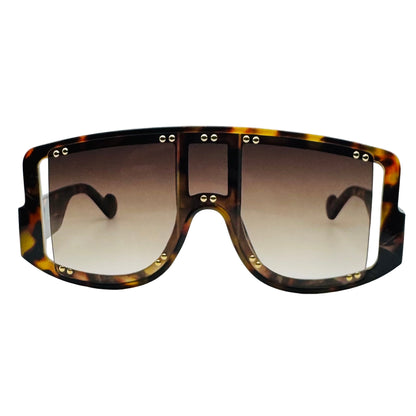 Sunglasses with tortoiseshell frame and gradient lenses on a light gray background