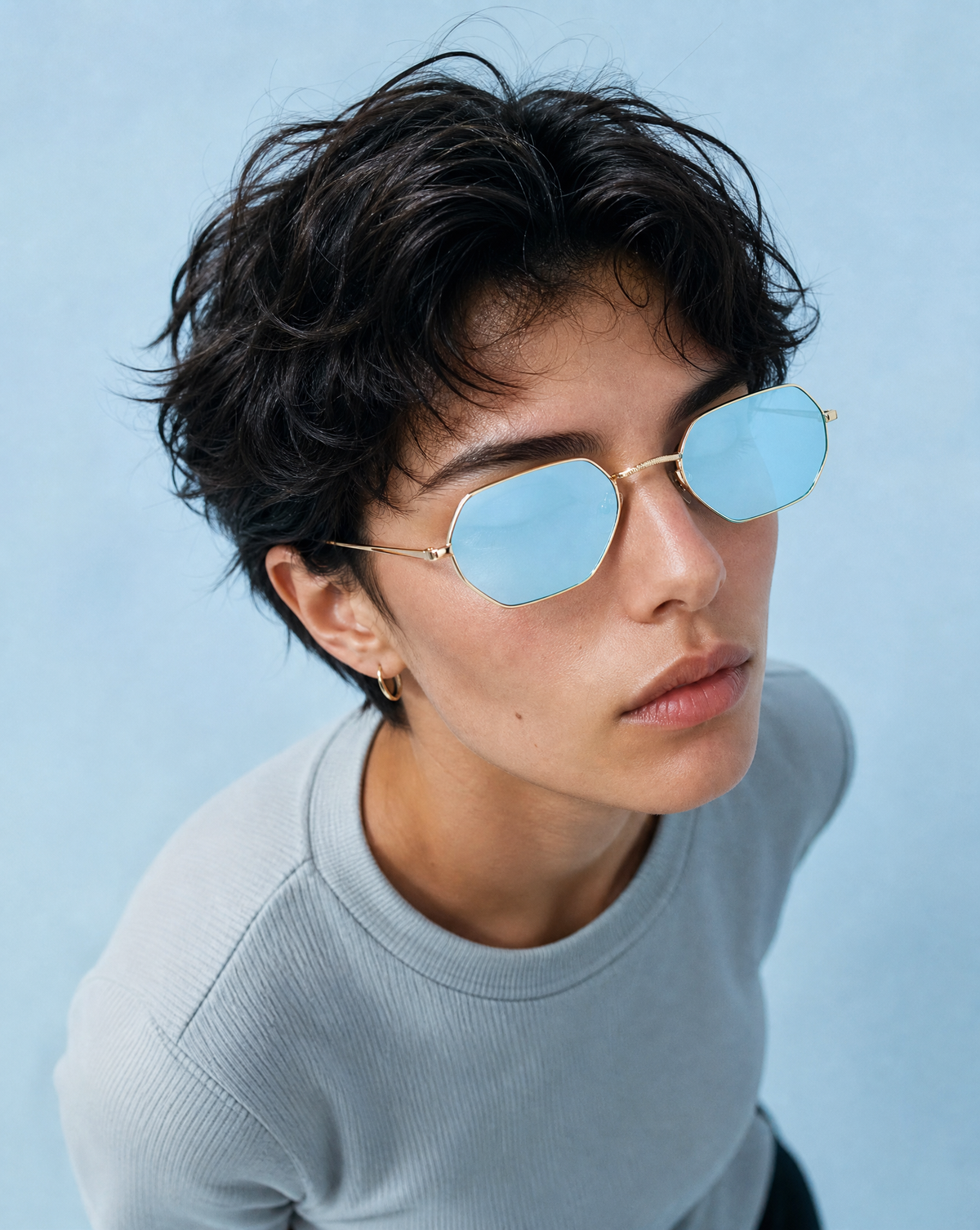 Model wearing the 5012 Hexon retro octagon sunglasses in Blue, showing the slim gold metal octagonal rims and light blue mirrored flat lenses